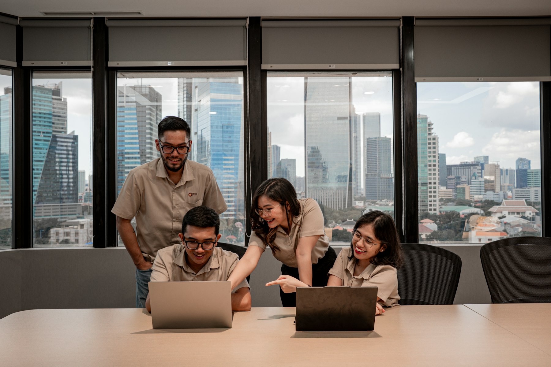 Technology team collaborating on laptops in a modern office
